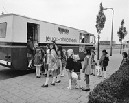 851221 Afbeelding van een rij kinderen (vooral meisjes) voor de ingang van de rijdende jeugd-bibliotheek in een ...